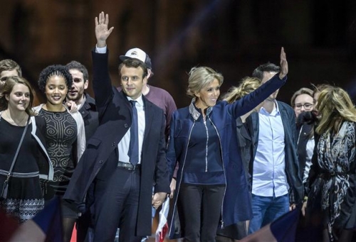 ▲에마뉘엘 마크롱(가운데 왼쪽) 프랑스 대통령 당선인과 부인 브리짓 트로뉴 여사가 7일(현지시간) 파리의 대형 쇼핑몰 까루젤 뒤 루브르에서 지지자들에게 손을 들어 보이며 대선 승리의 기쁨을 전하고 있다. 파리/EPA연합뉴스