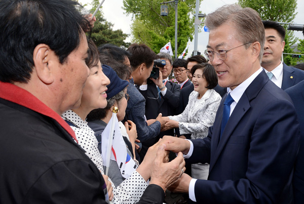 ▲지난 10일 오후 청와대 분수대 앞에서 문재인 대통령과 김정숙 여사가 환영나온 청운 효자 통인동 주민들과 손잡고 있다.
(연합뉴스)