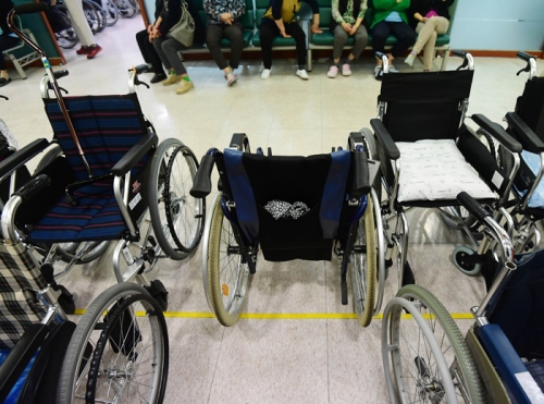 ▲여러 대의 휠체어가 물리치료실 앞에서 재활치료 중인 주인을 기다리고 있다. 