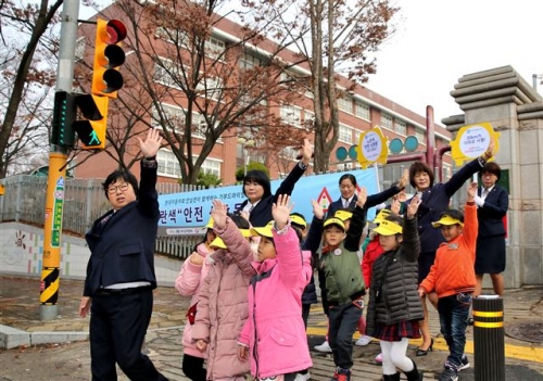 ▲현대차그룹이 어린이 통학사고 예방을 위해 서울의 한 스쿨존에 설치한 안전신호등을 보고 어린이들이 길을 건너고 있다.사진제공 현대자동차그룹

