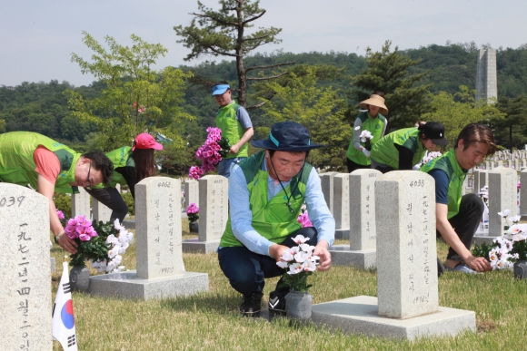 ▲(주)코오롱 임직원들은 31일 국립 서울현충원을 찾아 묘역정화 활동을 펼쳤다.(사진제공=코오롱)