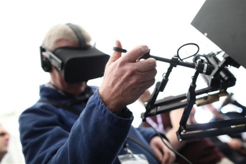 ▲영국에서 지난 4월 열린 한 콘퍼런스에서 참관객이 가상현실(VR) 헤드셋을 쓰고 치과 진료 시뮬레이션을 하고 있다. 블룸버그