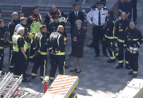 ▲테리사 메이(가운데) 영국 총리가 15일(현지시간) 전날 화재가 발생한 런던 서부 그렌펠타워 사고 현장을 방문한 모습. 사진=AP뉴시스