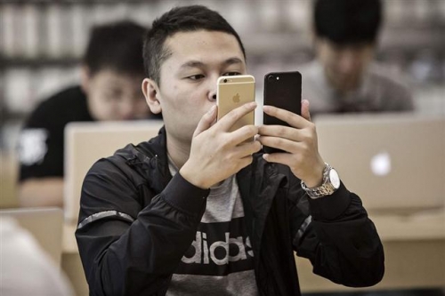 ▲중국 상하이의 애플 스토어에서 고객이 아이폰7 두 대를 서로 놓고 비교하고 있다. 블룸버그 