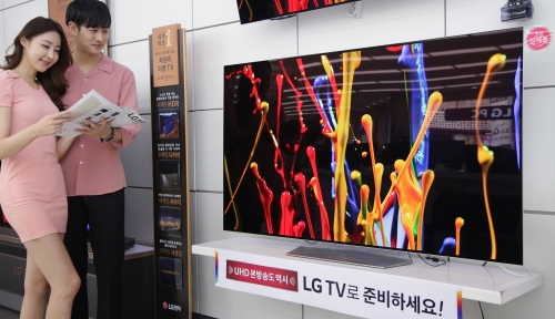 ▲ LG전자 모델들이 LG 베스트샵 매장에서 LG 올레드 TV를 살펴보고 있다.(사진제공=LG전자)