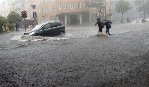 ▲지난달 30일(현지시간) 독일 오라니엔부르크에서 대규모 홍수가 발생한 가운데 행인들이 빗속에서 걷고 있다. 오라니엔부르크/AP연합뉴스