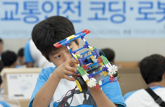 ▲르노삼성자동차가 지난 15일 서울 지역 초등학생을 대상으로 개최한 '어린이 교통안전 코딩 & 로봇 워크숍'에 참여한 학생이 모형차를 제작하고 있다. (사진제공=르노삼성자동차)