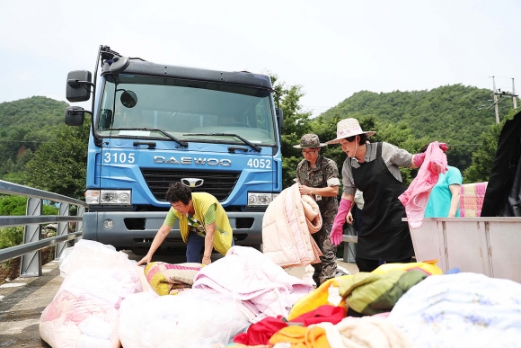 ▲김정숙 여사는 21일 폭우 피해로 어려움을 겪고 있는 충북 청주 지역을 찾아 피해주민·자원봉사자들과 복구작업을 함께 하고 있다. 사진제공=청와대