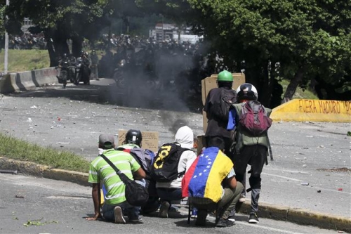 ▲베네수엘라 수도 카라카스에서 22일(현지시간) 반정부 시위대가 무장경찰에 맞서 시위하는 모습. 사진=AP뉴시스