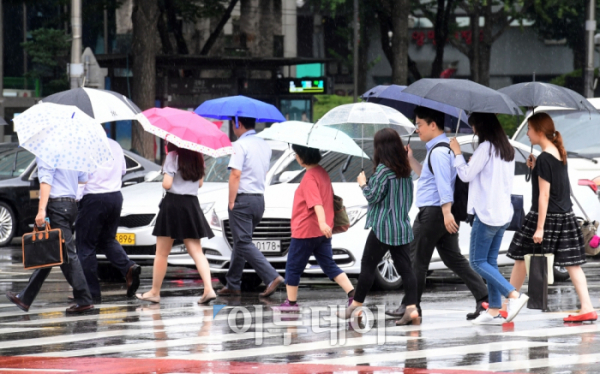 ▲서울에 장맛비가 내린 24일 서울 광화문 광장에서 우산을 쓴 외국인 관광객이 발걸음을 재촉하고 있다. 고이란 기자 photoeran@(이투데이DB)