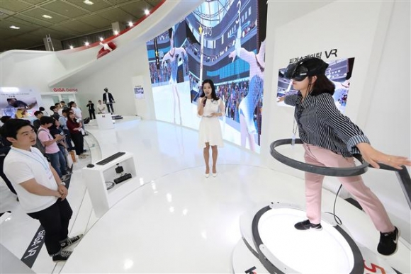 ▲지난 5월 서울 코엑스(COEX)에서 열린 국내 최대 정보통신박람회 ‘WORLD IT SHOW 2017’에서 KT ‘미리보는 평창 5G’ 전시관을 방문한 관람객이 VR 피겨스케이팅을 즐기고 있다. 사진제공= KT