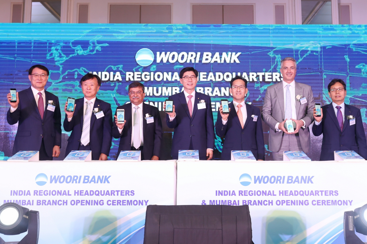 ▲3일 인도 뭄바이에서 열린 우리은행 인도지역본부와 뭄바이지점 개설 기념식에서 이광구 은행장(가운데)이 김성은 주 뭄바이 총영사(왼쪽 다섯 번째), 수더션 센(Sudarshan Sen) 인도 중앙은행 부총재(왼쪽 세 번째)를 비롯해 국내외 주요 인사들과 함께 글로벌 위비뱅크를 소개하며 기념촬영을 하고 있다. 사진제공 우리은행