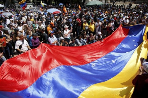 ▲베네수엘라 반정부 시위대가 지난 12일 수도 카라카스에서 베네수엘라 국기를 흔들고 있다. 사진=AP뉴시스