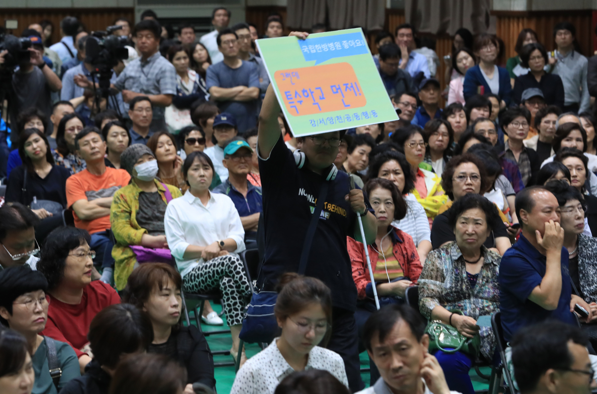 ▲지난 5일 오후 서울 강서구 탑산초등학교에서 열린 강서지역 특수학교 설립 교육감-주민토론회에서 한 참석자가 '특수학교 먼저'라고 적힌 피켓을 들고 있다.(사진=연합뉴스)