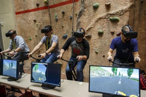 ▲올해 1월 미국 라스베이거스에서 열린 소비자가전쇼에서 참관객들이 VR 헤드셋과 연동된 실내 자전거를 체험하고 있다. 블룸버그 