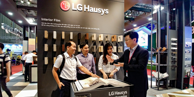 ▲LG하우시스가 이달 초 베트남 지사 설립을 완료하고 27일부터는 베트남 최대 건축자재 전시회 '베트빌드(Vietbuild)'에 참가해 인조대리석, 바닥재 등 다양한 현지 특화 제품을 선보였다. 전시회에서 LG하우시스 직원이 전시관을 찾은 방문객에게 벽지 제품을 설명하고 있다. (사진제공=LG하우시스)