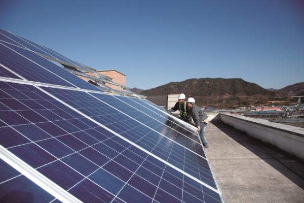 ▲한화그룹 직원들이 복지시설 옥상에 태양광 발전설비를 설치하고 있다.(사진제공=한화)