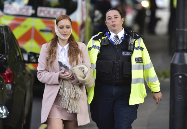 ▲15일(현지시각) 영국 런던 아침 출근길 지하철에서 발생한 폭발 사고로 다친 여성이 안전요원의 도움을 받아 걸어가고 있다.(@뉴시스 )
