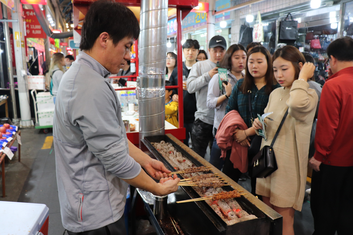 ▲21일 오산 오색시장 내 연길양꼬치 앞에 설치된 양꼬치 부스 앞에서 사람들이 긴 줄로 늘어서 순번을 기다리고 있다.  전효점 기자 gradually@