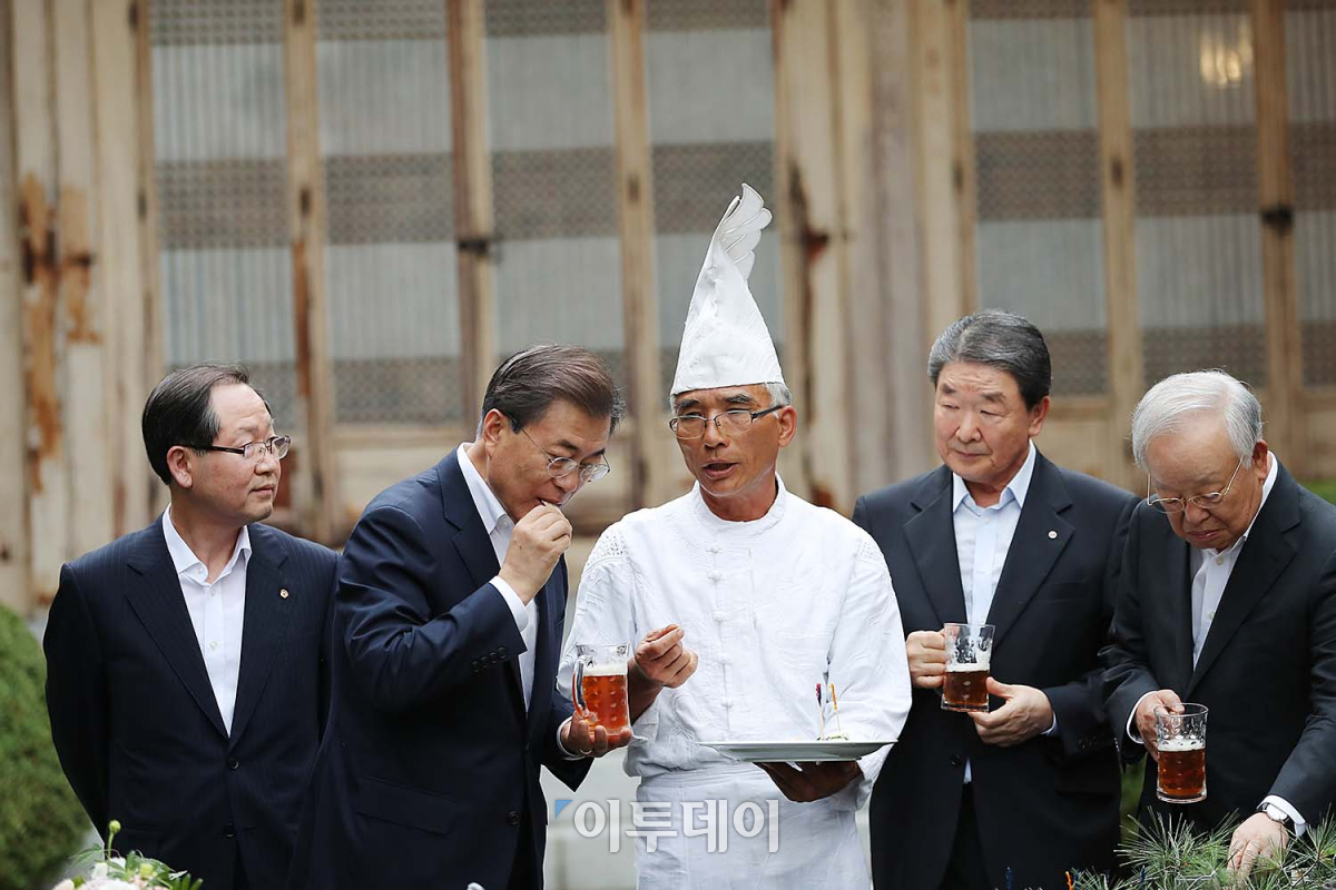 ▲문재인 대통령이 7월 27일 청와대 상춘재 열린 주요 기업인과의 호프미팅에서 '방랑식객'이란 별명으로 유명한 임지호 셰프(가운데)가 만든 음식을 맛보고 있다. (사진제공=청와대)