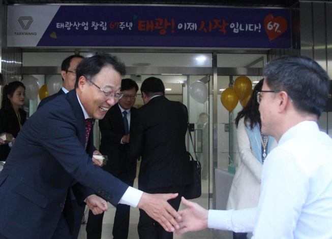 ▲지난 24일 진행한 태광산업 창립 67주년 기념 행사에서 홍현민 대표이사가 서울 중구 장충동 사옥 앞에 나와 직원들을 맞이하고 있다.(사진제공=태광산업)