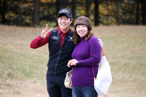 ▲1번홀 티샷후 어머니와 포즈를 취하고 있는 김우현.