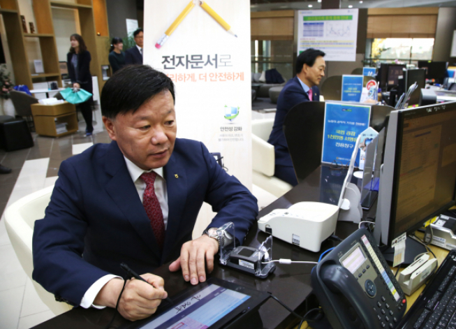 ▲NH투자증권은 증권업계 최초로 영업점에서 전자문서로 업무를 처리하는 시스템을 도입했다고 13일 밝혔다. 김원규 사장이 영업점에서 전자문서를 이용해 현금을 출금하고 있다.(사진제공=NH투자증권)