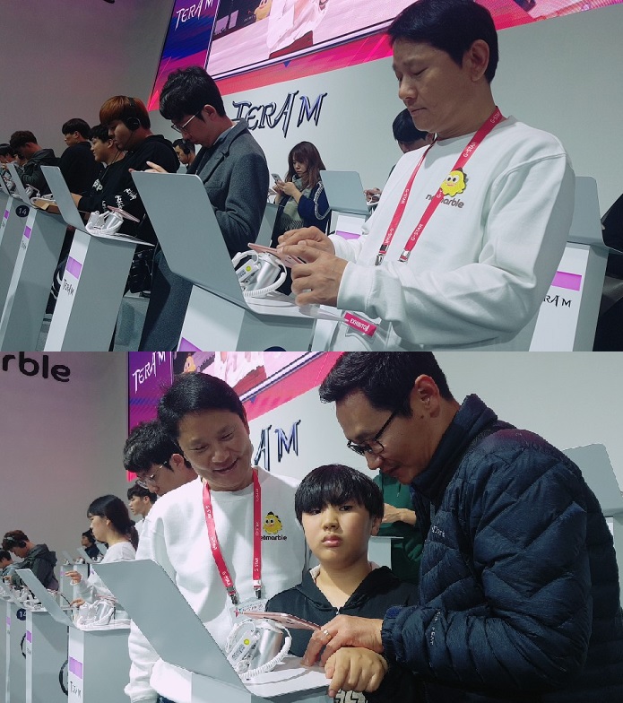 ▲권영식 넷마블게임즈 대표가 17일 '지스타2017' 넷마블 부스에서 직접 관람객을 맞이하는 일일 운영요원으로 변신해 게임에 대한 설명을 하고 있다. (이투데이DB)