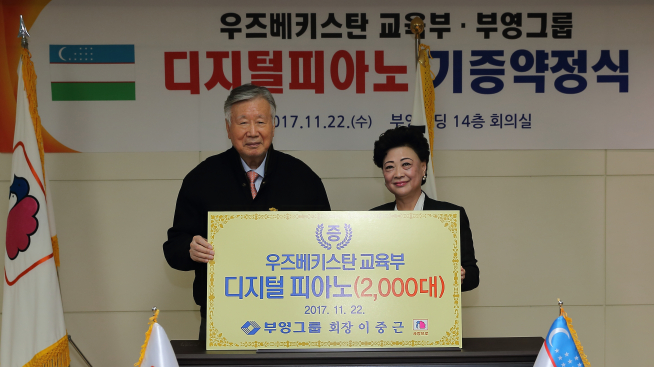 ▲부영그룹 이중근 회장(왼쪽)이 22일 우즈베키스탄 신 아그레피나 교육부 장관과 디지털피아노 2000대 기증 약정식을 맺었다(사진=부영그룹)