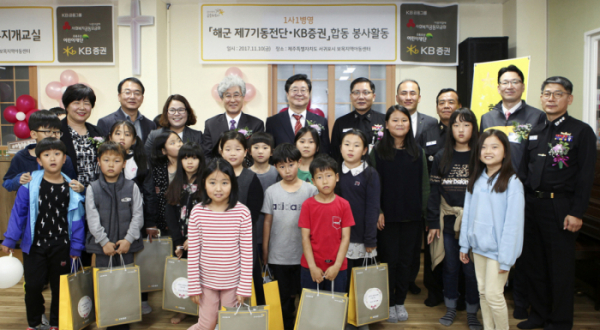 ▲지난 10일 제주 보목지역아동센터에서 열린 '무지개교실'행사에서 KB증권 전병조사장(뒷줄 오른쪽에서 여섯번째)과 김정수 해군 7기동전단장(뒷줄 오른쪽에서 다섯번째)을 비롯한 KB증권 임직원들과 해군장병 및 보목지역아동센터 관계자들과 지역어린이들이 기념촬영을 하고 있다. KB증권