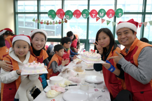 ▲SK건설 임직원 가족이 직접 만든 케이크를 들고 기념촬영을 하고 있다.(사진=SK건설)