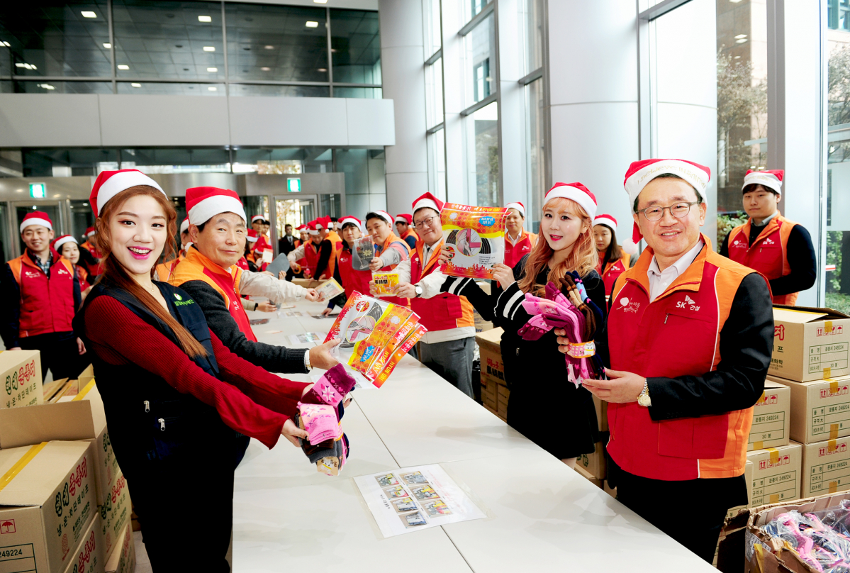 ▲6일 조기행 SK건설 부회장(첫째줄 오른쪽)과 임직원, 베이비부 멤버들(남색조끼 착용)이 행사 진행 중에 방한물품을 들고 기념 촬영을 하는 모습.(사진=SK건설)