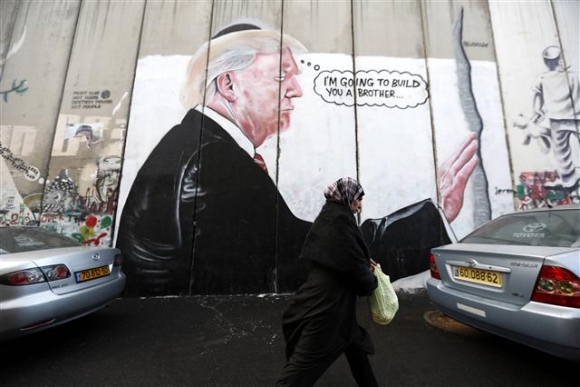 ▲이스라엘 베들레험 웨스트뱅크 시의 한 건물 담벼락에 도널드 트럼프 미국 대통령이 유대인 전통모인 키파를 쓰고 기도하는 모습이 그려져 있다. 베들레헴/EPA연합뉴스