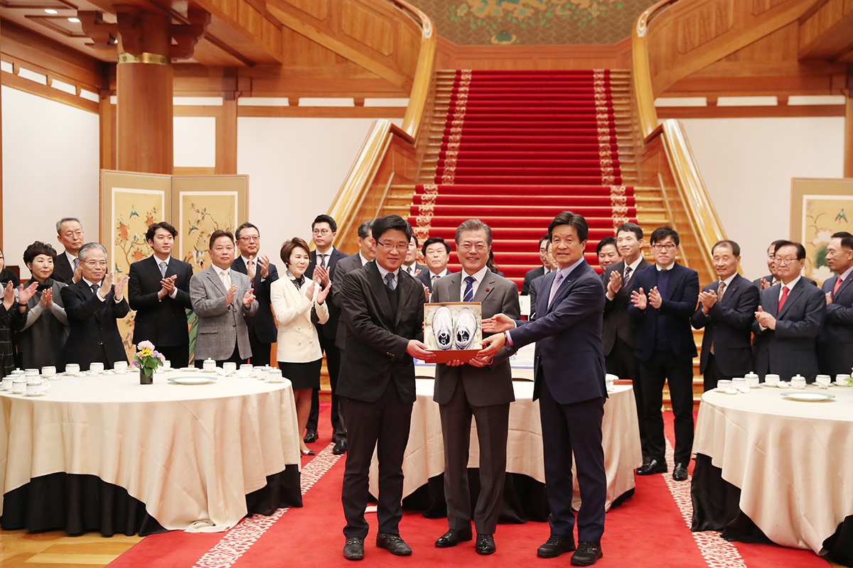 ▲문재인 대통령이 16일 오후 청와대 본관 로비에서 열린 중소·벤처기업 및 소상공인과의 대화에서 창업 실패 후 다시 창업을 준비중인 강정완 ㈜공사박사 대표(왼쪽)에게 재창업의 성공을 기원하며 '운동화'를 선물하고 있다.(사진제공=청와대)