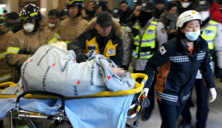 ▲화재로 대형참사가 발생한 26일 오전 경남 밀양 세종병원 현장에서 대한적십자 봉사자와 소방대원들이 환자를 긴급 이송하고 있다. (대한적십자/연합뉴스)
