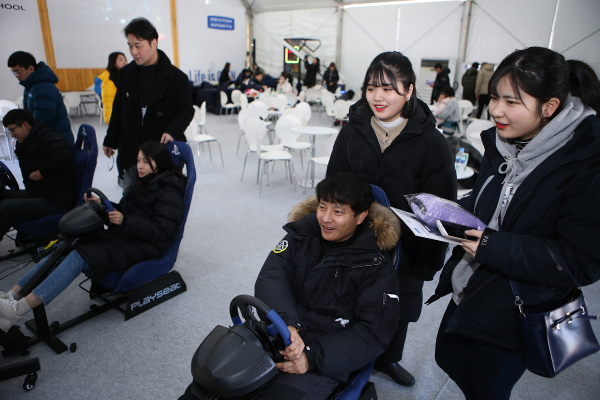 ▲가족 참가자들이 레이싱 시뮬레이터 게임을 함께 즐기고 있다.