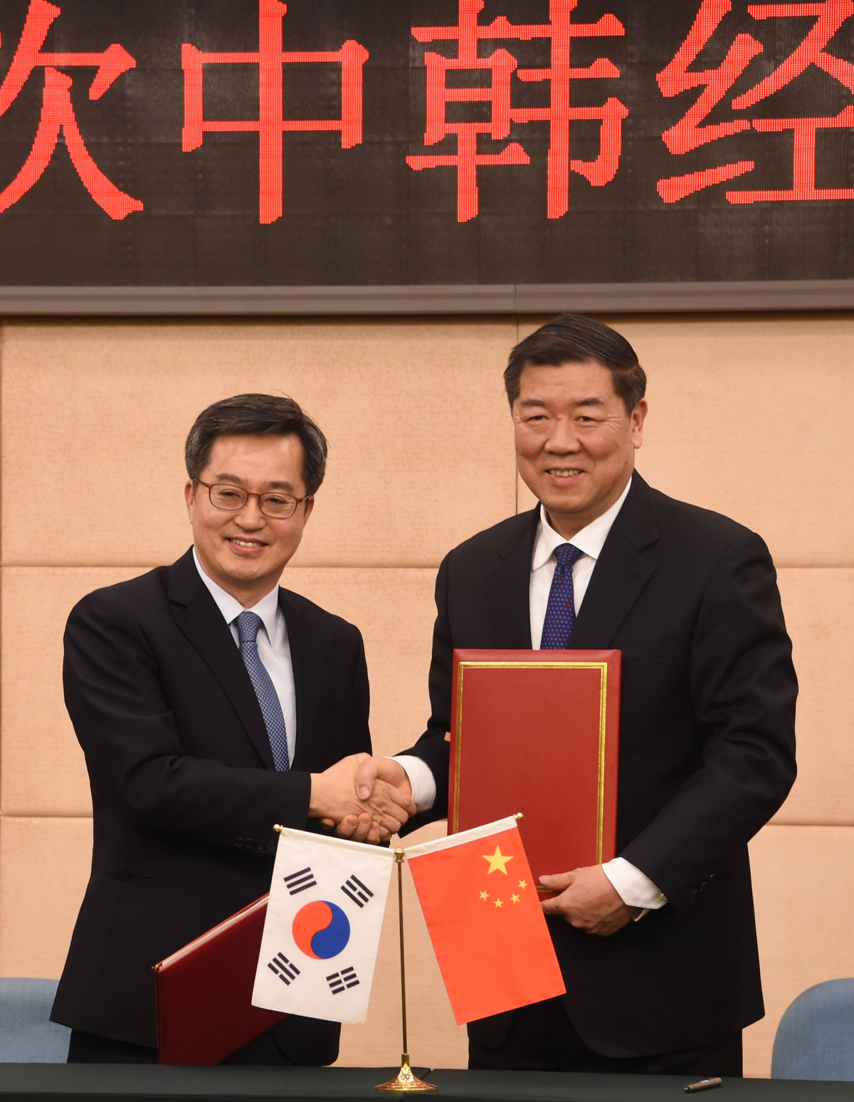 ▲김동연 부총리(왼쪽)가 2일 중국 북경 국가발전개혁위원회에서 열린 15차 한중경제장관회의에 참석해 허 리펑 발개위 주임과 합의의사록에 서명한 후 악수하고 있다.(기획재정부)