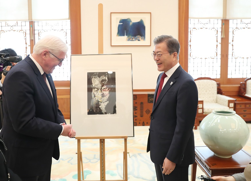 ▲문재인 대통령이 8일 오전 청와대 본관에서 열린 프랑크-발터 슈타인마이어 독일 대통령과의 정상회담에 앞서 독일 대통령으로 부터 동독출신의 영화배우이자 화가 ‘아르민 뮐러 슈탈’이 빌리브란트 전 총리를 상징적으로 그린 작품을 선물받고 있다.(연합뉴스)