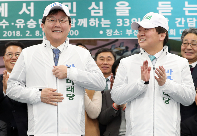 ▲국민의당 안철수 대표가 8일 오후 부산 연제구 부산시의회에서 열린 '부산에서 민심을 듣는다' 간담회에 앞서 바른미래당 당명이 적힌 옷과, 모자, 신발을 착용하고 바른정당 유승민 대표를 바라보고 있다. 2018.2.8(연합뉴스)