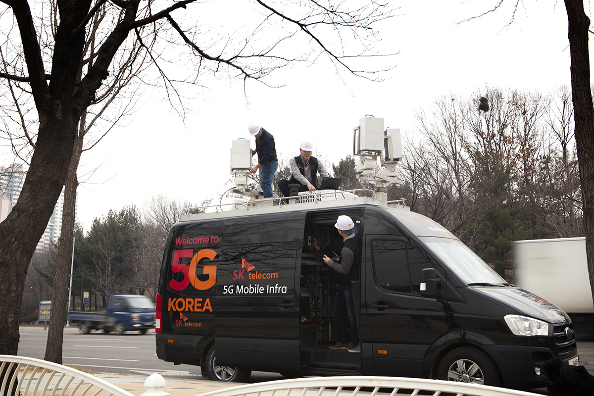 ▲SK텔레콤 네트워크 기술원 연구원들이 분당구청 잔디광장에 '이동형 5G 인프라'를 설치하고, 가상화 플랫폼으로 소프트웨어를 변경하며 5G 성능을 최적화하고 있다.(사진제공= SK텔레콤)
