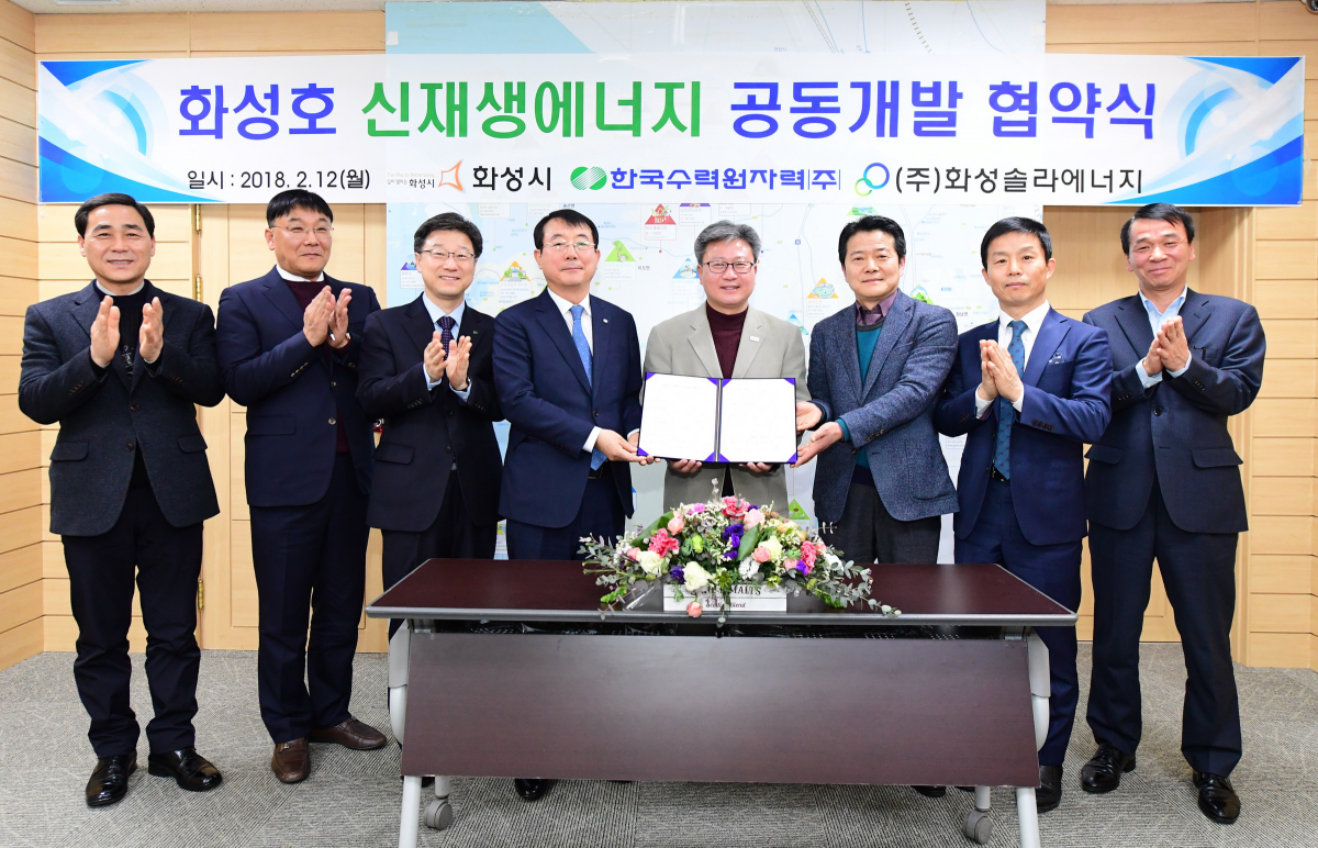 ▲오순록 한국수력원자력 그린에너지본부장(왼쪽 세번째부터), 채인석 화성시장, 윤진수 화성솔라에너지 윤진수 대표 등이 12일 화성시청에서 국내 최대 규모인 100㎿ 규모의 수상태양광 발전설비 건설과 신재생에너지 공동개발을 위한 협약을 맺고 기념촬영을 하고 있다.(한국수력원자력)