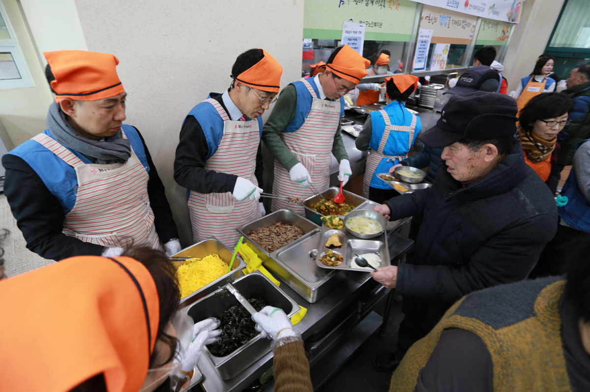 ▲13일 포스코건설 임직원들이 인천 연수구 노인복지관에서는 지역 노인들에게 떡국을 대접하는 모습.(사진=포스코건설)