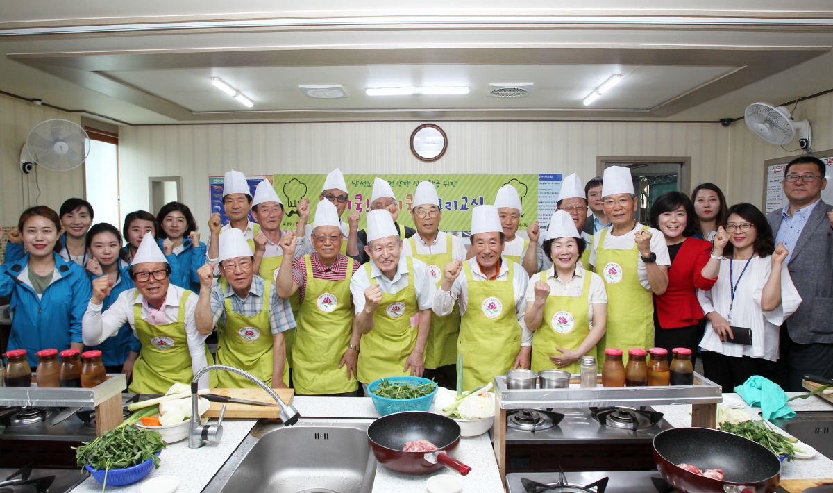 ▲한국동서발전의 사회 공헌 프로그램 중 하나인 ‘나홀로 어르신 요리수업’ 참가자 등이 기념촬영을 하고 있다. 사진제공 한국동서발전