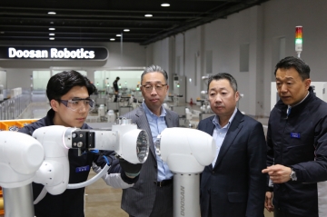▲두산로보틱스가 개발한 협동로봇을 살펴보고 있는 박정원(오른쪽 두 번째) 두산그룹 회장과 박지원(왼쪽 두 번째) 부회장.  사진제공 두산그룹