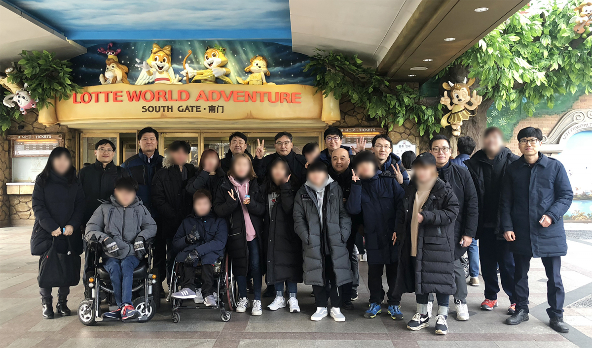 ▲롯데건설 기술연구원의 샤롯데봉사단이 SRC 보듬터 이용자들과 함께 롯데월드 방문 기념 촬영 중이다.(사진출처=롯데건설)