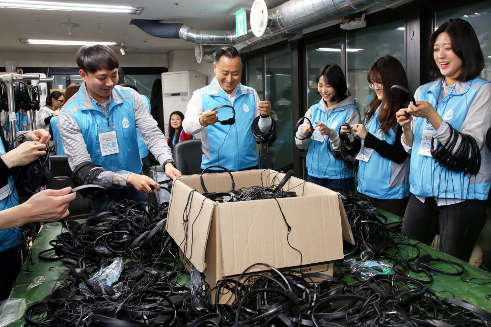 ▲이해선 코웨이 대표이사와 신입사원들이 지난 16일 서울 관악구에 위치한 실로암시각장애인복지관을 찾아 시각장애 근로자의 헤드폰 포장조립 작업을 보조하고 있다.(사진제공=코웨이)