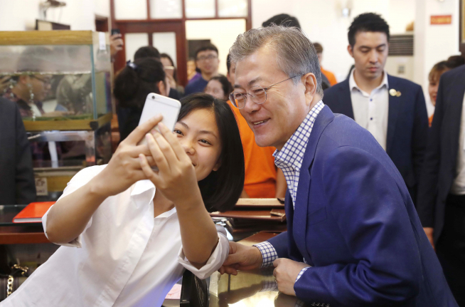 ▲베트남을 국빈 방문 중인 문재인 대통령이 아침식사를 하기 위해 24일 베트남 3대 쌀국수집 중의 하나인 포10리쿠옥쓰 식당을 찾아 현지 시민과 기념촬영을 하고 있다.(연합뉴스)