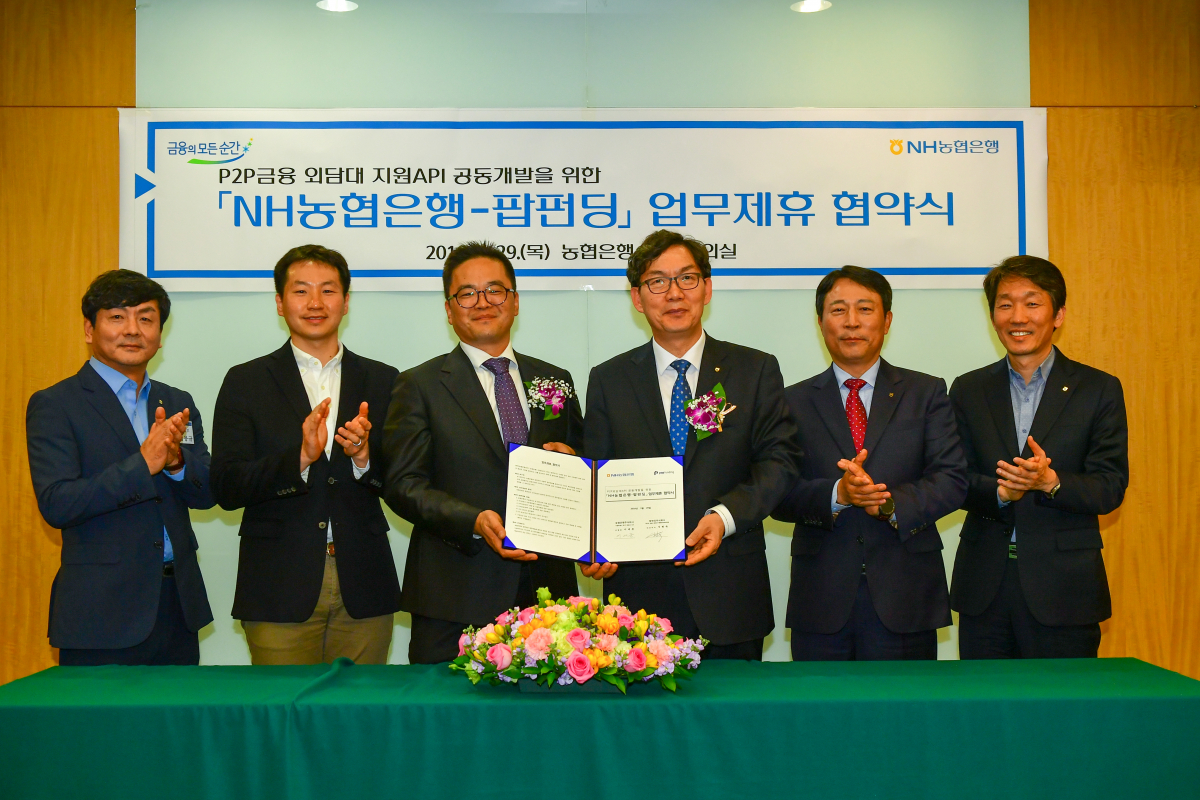 ▲김봉규 NH농협은행 팀장, 김성욱 팝펀딩(주) 이사, 신현욱 팝펀딩(주) 대표이사, 이대훈 NH농협은행장, 주재승 NH농협은행 디지털전략부문 부행장, 이창기 NH농협은행 디지털전략부장이 업무제휴 협약식 기념 촬영을 하고 있다.