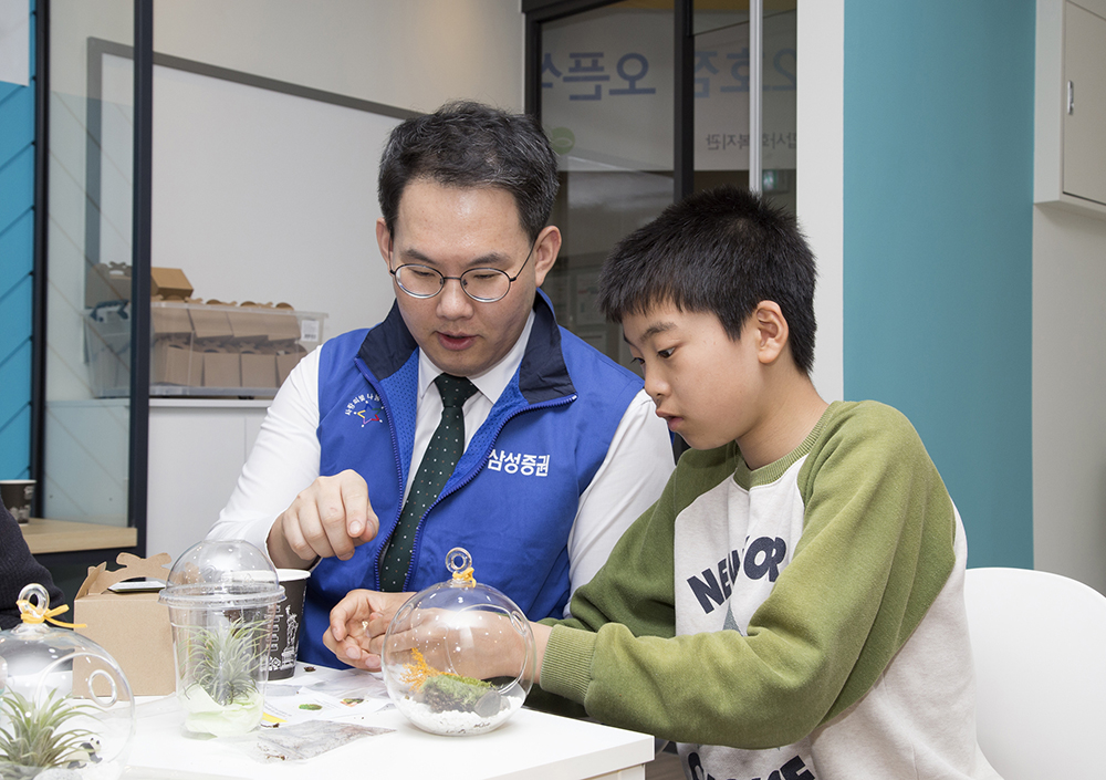 ▲삼성증권은 지역 청소년을 위한 공부방 ‘꿈마루’를 서울 동작구 대방종합사회복지관에 열었다. 삼성증권 직원이 꿈마루에서 학습 활동을 진행하고 있다.(사진제공=삼성증권)