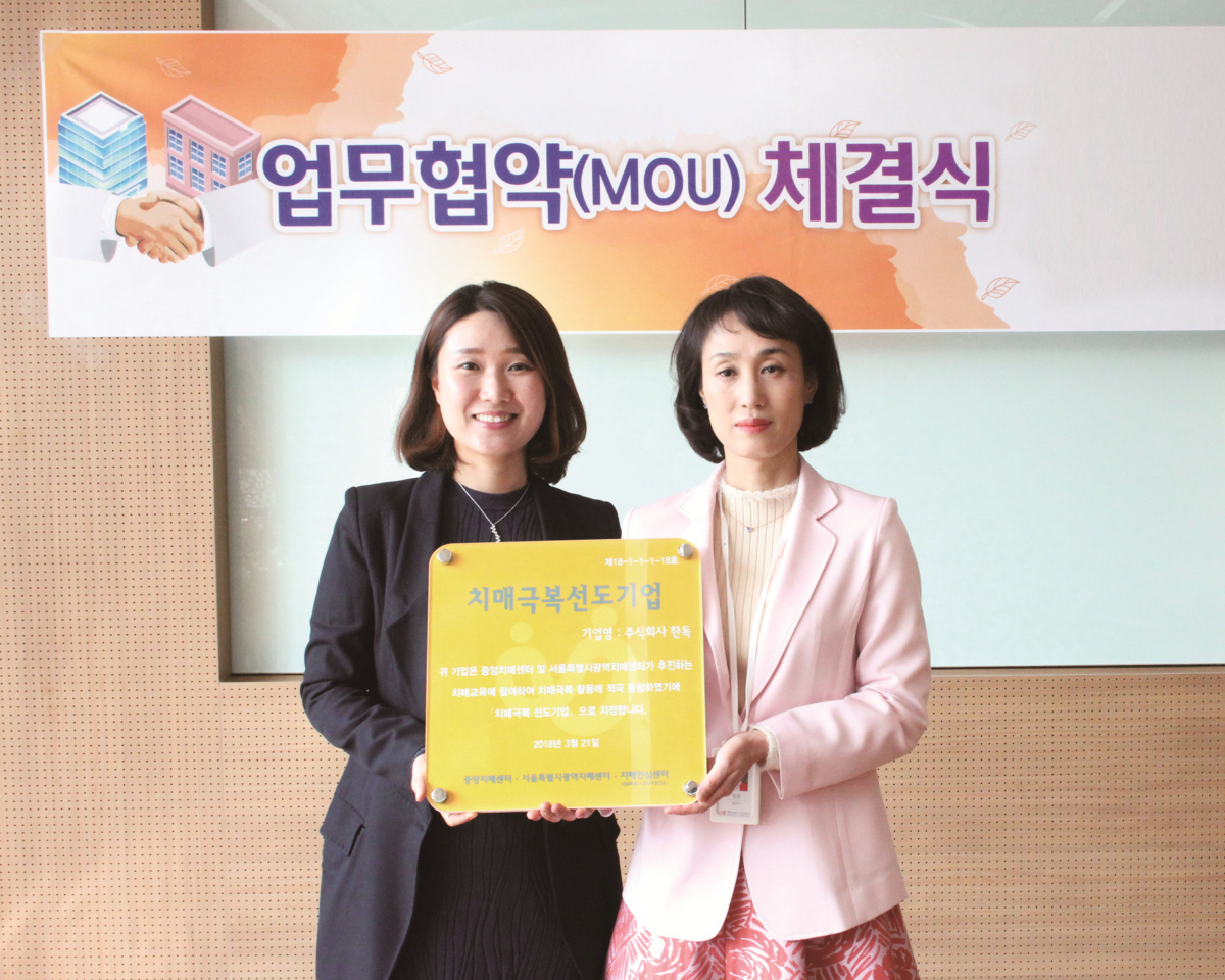 ▲허은희(왼쪽) 한독 상무와 정은주 강남구치매안심센터 팀장이 치매 선도 기업에 대한 현판식을 전달하는 업무협약을 체결하고 있다.(한독)